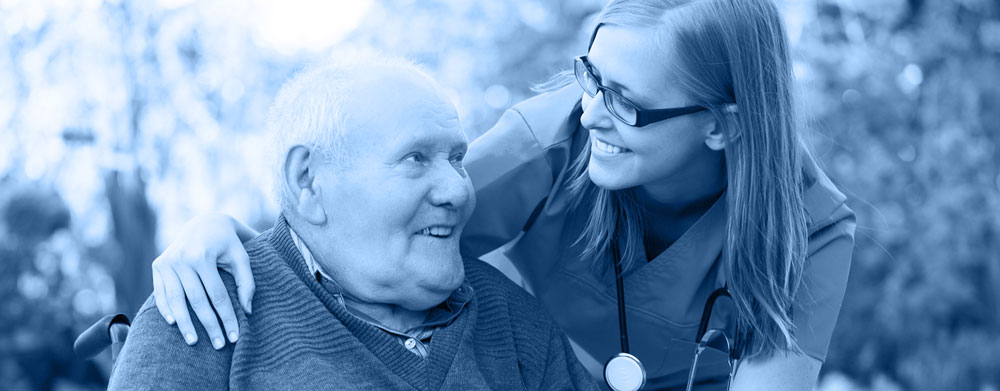 Medium shot of a young female nurse supporting an elderly man in a wheelchair.